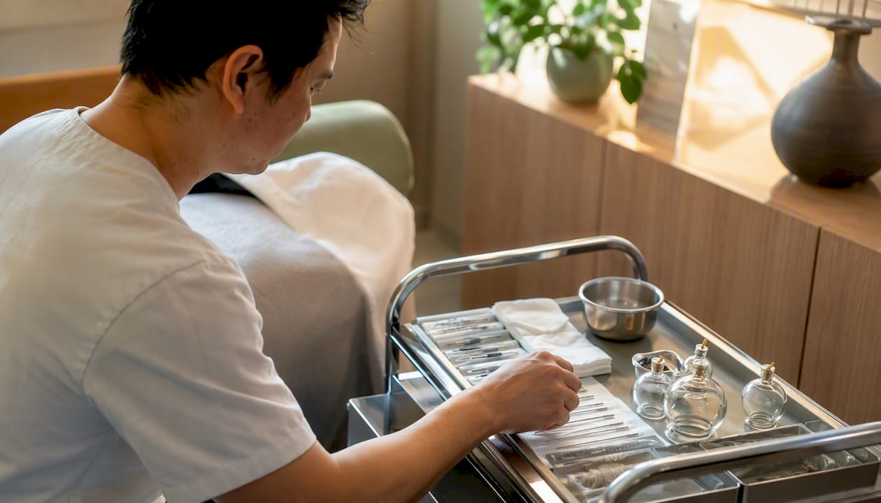 Un professionnel dispose délicatement des aiguilles d’acupuncture dans une salle de soins à l’hôpital.