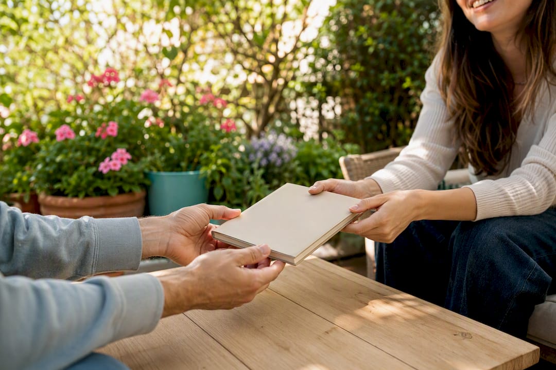 Des mains se passant une tablette, symbolisant l'interaction entre pairs en ligne